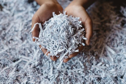 Shredded paper being scooped up by a person in two hands